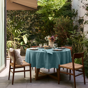Aquamarine Blue Linen Round Tablecloth in an Outdoor Garden Dining Setting with Lush Greenery