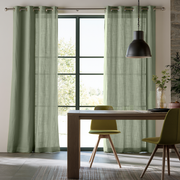 Light Asparagus Green Grommet Curtains Hanging on a Metal Rod in a Bright Dining Room