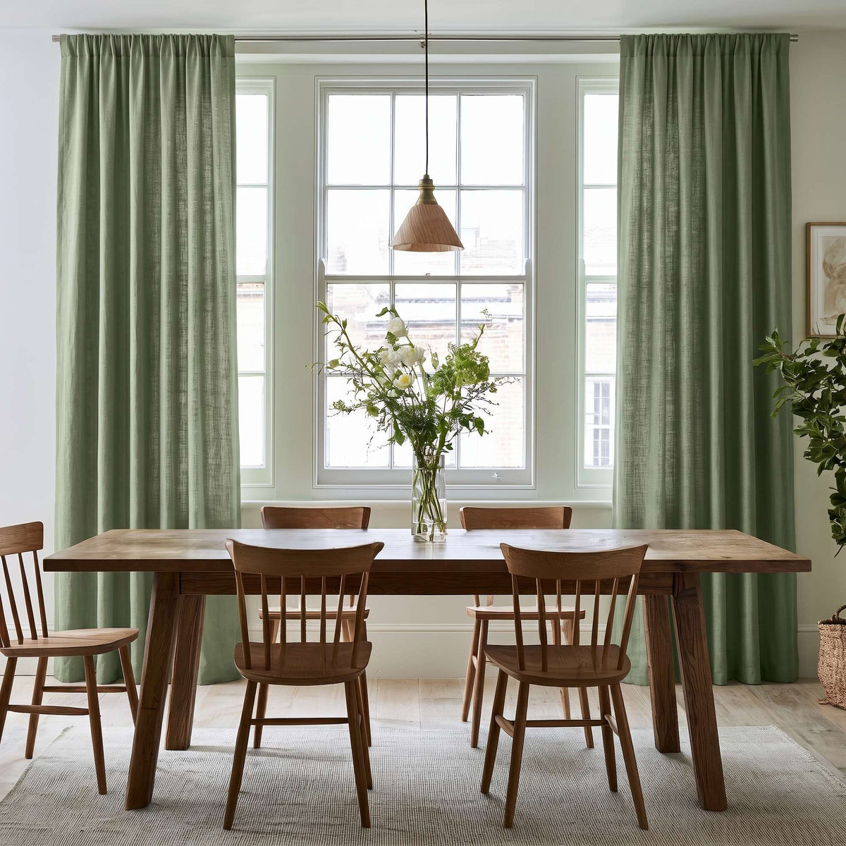 A Dining Room Scene With Asparagus Green Curtains Hanging On Both Sides Of A Large White Window