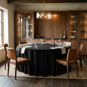 Black Linen 132 Inch Round Tablecloth in a Warm Dining Room with Walnut Cabinetry