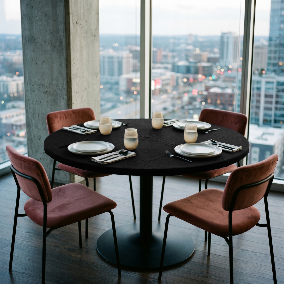 Black Linen Fitted Round Tablecloth in a City View Dining Room with Concrete Walls and Dusty Rose Velvet Chairs
