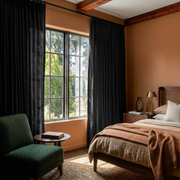 Black Linen Pencil Pleat Curtains in a Warm Terracotta Bedroom with Rustic Wood Beams - Cotton Lining