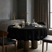 Black Linen Round Tablecloth in a Modern Dining Room with Charcoal Gray Walls and Dark Wood