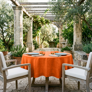 Burnt Orange Linen 42 Inch Round Tablecloth in a Mediterranean Patio Dining Space with Weathered Wood and White Cushion