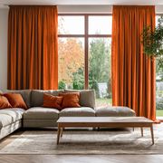 Burnt Orange Linen Pencil Pleat Extra Long Curtains in a Modern Living Room with a Light Gray Sectional Sofa, Matching Orange Accent Pillows and a Garden View
