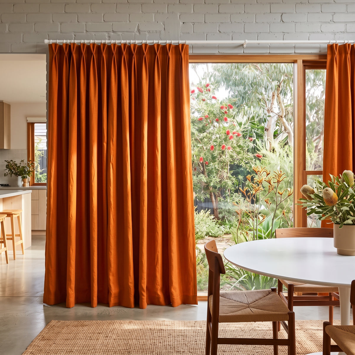 Burnt Orange Linen Pinch Pleat Curtains in an Open Plan Dining Room with Light Grey Painted Brick Walls and a Round White Table Alongside Woven Wood Chairs - Blackout Lining