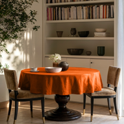 Burnt Orange Linen Round Tablecloth in a Cozy Dining Room with White Built-In Shelving and Tan Velvet Chairs