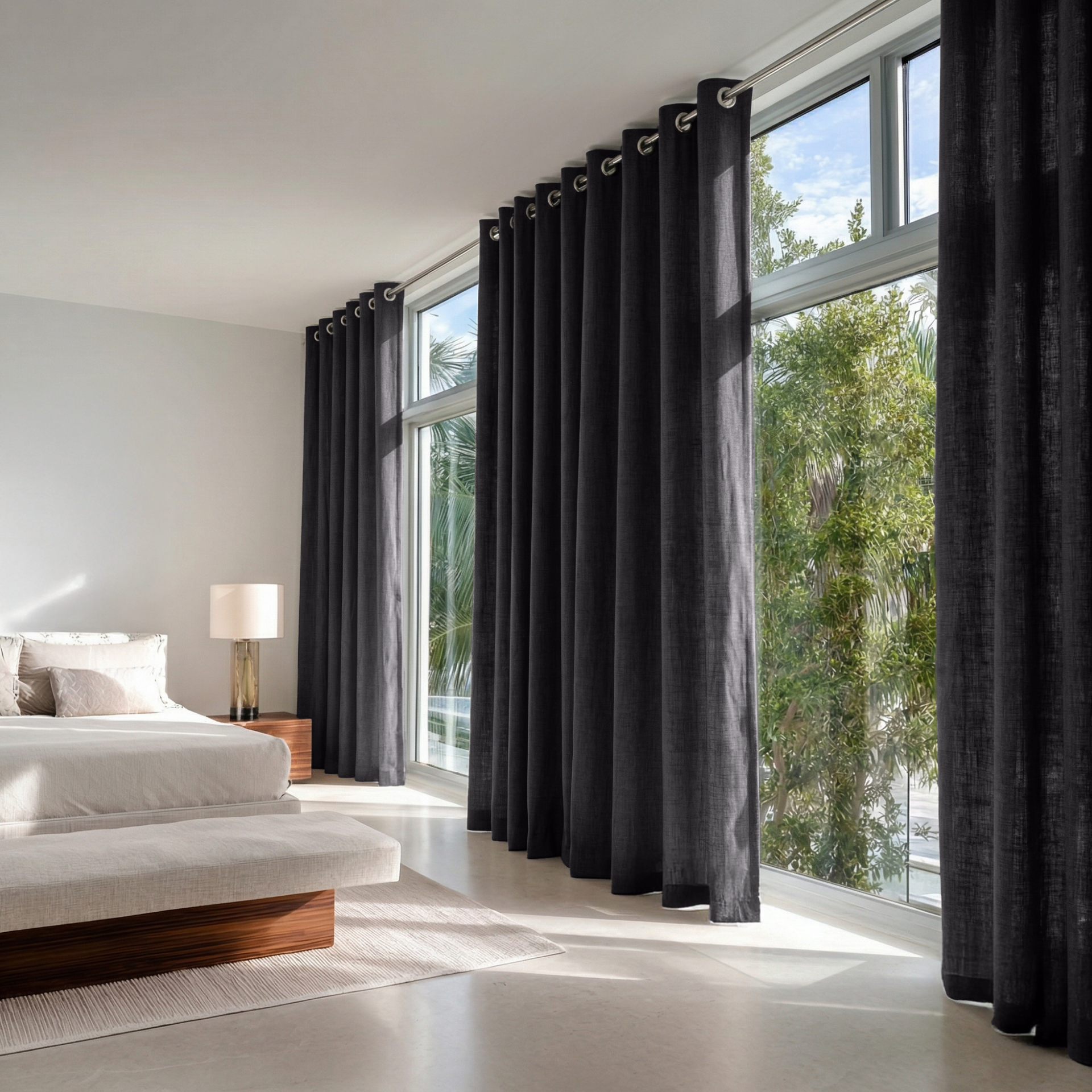 Charcoal Grey Linen Grommet Curtains in a Bright Minimal Bedroom with Warm White Walls and Light Flooring