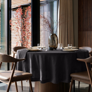 Charcoal Grey Linen Round Tablecloth in a Modern Dining Room with Black Framed Windows and Walnut Wood Accents