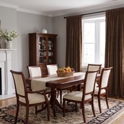Chocolate Brown Velvet Curtains in a Spacious Gray Dining Room with a Brown Wooden Table and Upholstered Wooden Chairs, Fruit Bowl