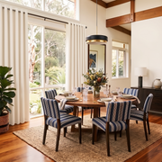 Cream Linen Grommets Dining Room Curtain in a Transitional Dining Room with White Walls and Striped Upholstered Chairs Around a Round Wooden Table - Blackout Lining