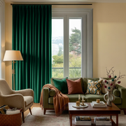 Emerald Green Velvet Pinch Pleat Blackout Curtains in a Living Room with Cream Walls
