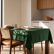 Forest Green Rectangular Linen Tablecloth in a Contemporary Kitchen with Cane-Back Chairs and Warm Wood Cabinetry