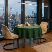 Forest Green Linen Small Round Tablecloth in a Modern City Dining Room with Floor-To-Ceiling Windows and Cream Velvet Chairs