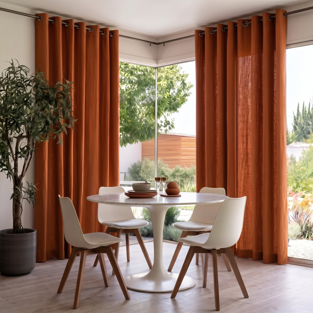 Heavy Weight Terracotta Linen Grommets Dining Room Curtain in a Modern Dining Room with White Walls and a White Marble Table Surrounded By White Shell Chairs.