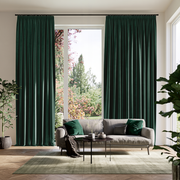 Hunter Green Velvet Pencil Pleat Extra Long Curtains in a Contemporary Living Room Setting With a Gray Sofa, Green Pillows, and Plants