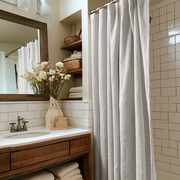 Off-White Heavy Weight Linen Button-Hole Top Weighted Shower Curtain in a Cozy Bathroom Interior with Wooden Elements and Plush Towels