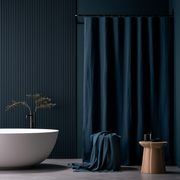Peacock Blue Linen Button-Hole Top Weighted Shower Curtain in a Modern Bathroom with a Ribbed Navy Wall