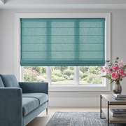 Aquamarine Roman Shades in a Contemporary Living Room with Light Grey Walls, a Blue Velvet Sofa and a Modern Coffee Table.