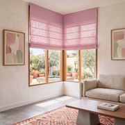 Dusty Rose Roman Shades in a Modern Living Room with Cream Walls and a Geometric Pattern Rug