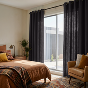 Charcoal Grey Linen Grommet Curtains in a Warm Bedroom with Soft Cream Walls