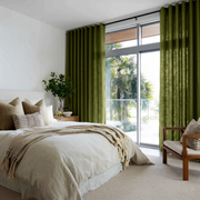Moss Green Linen Grommet Bedroom Curtains in a Bright Coastal Bedroom with Layered Oatmeal Bedding and Taupe Accents