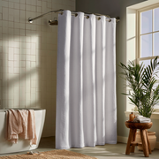 Off-White Heavy Weight Linen Hookless Weighted Shower Curtain beside a White Bathtub with a Draped Waffle Towel