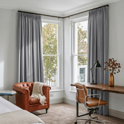 Stone Grey Linen Pencil Pleat Curtains in a Crisp White Bedroom with Light Wood Accents and a Cozy Reading Corner - Blackout Lining