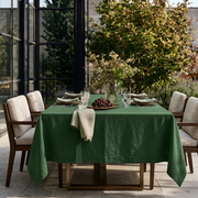 Forest Green Rectangular Linen Tablecloth on a Contemporary Outdoor Patio with Upholstered Dining Chairs