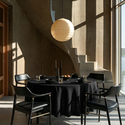 Black Linen Round Tablecloth in a Contemporary Dining Room with Warm Taupe Plaster Walls and Black Wood