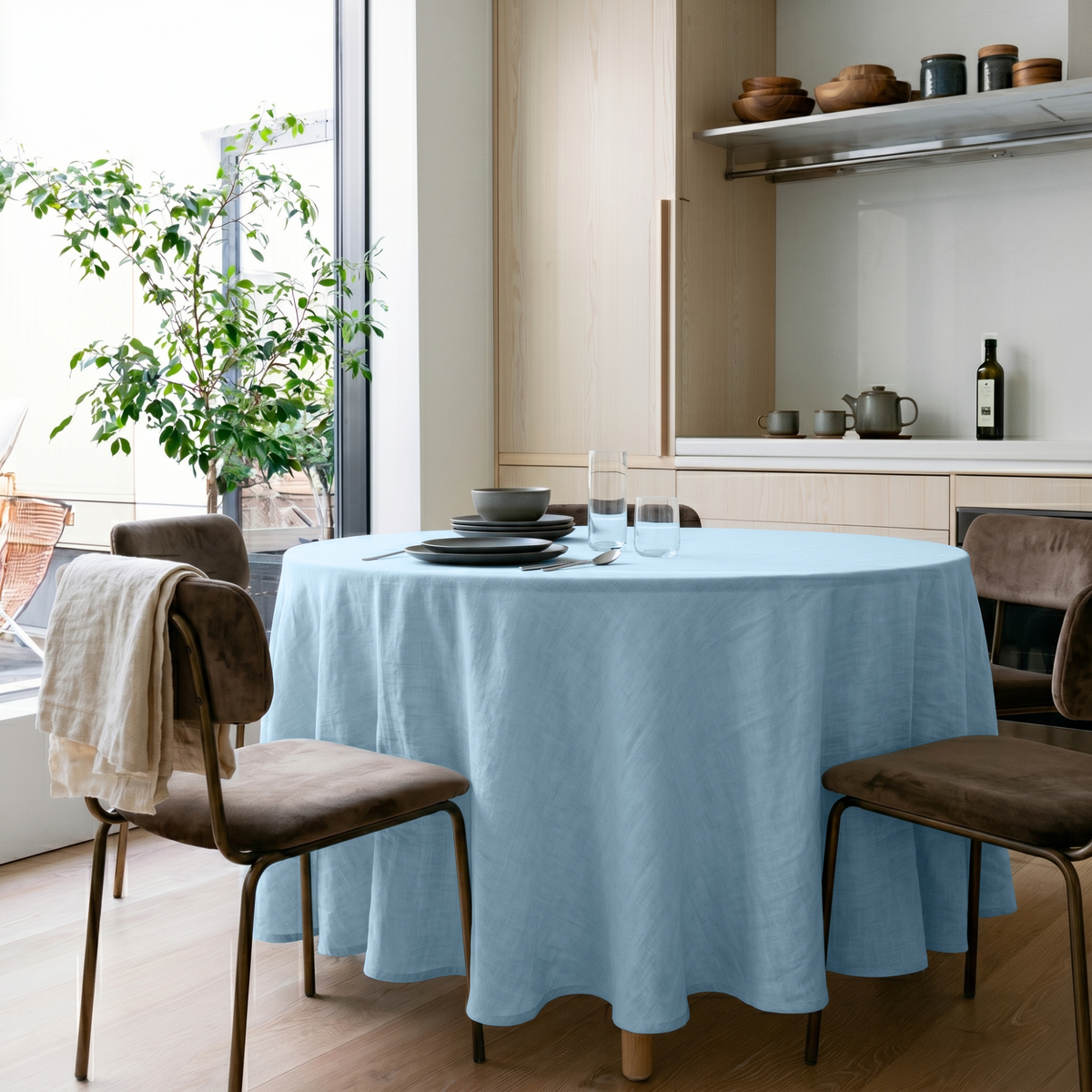 Sky Blue Linen Round Tablecloth in a Bright Minimal Kitchen with Pale Wood Cabinets and Soft Taupe Accents
