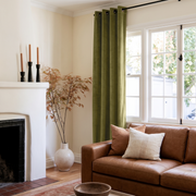 Moss Green Velvet Grommet Curtains in a Modern Living Room with Cream Walls and a Caramel Leather Sofa