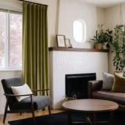 Moss Green Velvet S-Fold Curtains in a Mid-Century Living Room with a White Tiled Fireplace and Brown Leather Sofa