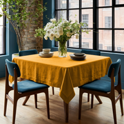Mustard Yellow Square Linen Tablecloth in an Industrial Dining Room with Blue Upholstered Chairs