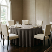 Natural Heavy Weight Linen 132 Inch Round Tablecloth in an Elegant Dining Room with Taupe Paneled Walls and Cream Bouclé Chairs