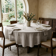 Natural Linen 120 Inch Round Tablecloth in a Warm Dining Room with Beige Plaster Walls and Walnut Wood