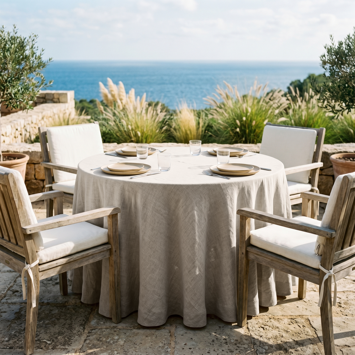 Natural Linen 132 Inch Round Tablecloth in a Mediterranean Patio Dining Space Weathered Wood and Cream Cushion