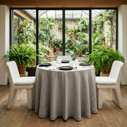 Natural Linen 84 Inch Round Tablecloth in a Plant-Filled Dining Nook with White Walls and Black Ceramic
