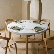 Off-White Fitted Velvet Round Tablecloth in a Minimal Dining Room with Plaster Arches and Light Wood Chairs