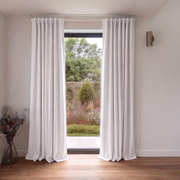 Off-White Heavy Weight Linen Back Tab Extra Long Curtains in a Minimalist Room with Garden Views and Warm Wood Flooring