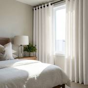 Off-White Heavy Weight Linen Grommet Curtains in a Light Neutral Bedroom With White Bedding and Soft Gray Accents