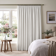 Off-White Heavy Weight Linen Pencil Pleat Extra Long Curtains in a Bright Bedroom with Large Windows and Natural Wood Furniture