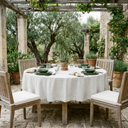 Off-White Linen 90 Inch Round Tablecloth in a Rustic Patio Dining Space with Stone Columns and Natural Wood