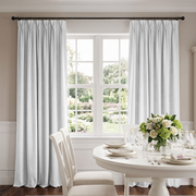 Elegant floor-length Off-White curtains framing a large window in a bright, refined dining room