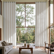 Off-White Linen Grommet Extra Long Curtains in a Contemporary Living Room with Double-Height Windows and Garden Views