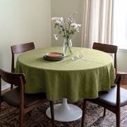 Olive Green Linen Round Tablecloth in a Cozy Dining Room with Pale Sage Walls and Walnut Wood, Dark Leather and Soft Neutral Accents