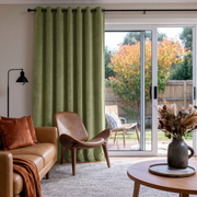 Olive Green Velvet Grommet Sliding Patio Door Curtains in a Mid-Century Living Room with Cream Walls and Caramel Leather Seating