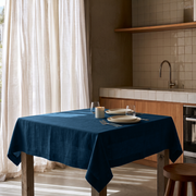 Peacock Blue Square Linen Tablecloth in a Contemporary Kitchen with Warm Wood Cabinetry and White Tiled Backsplash
