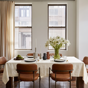 Cream Rectangular Linen Tablecloth in a Contemporary Dining Room with Leather Chairs and White Floral Centerpiece