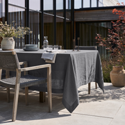 Dim Grey Rectangular Linen Tablecloth in a Contemporary Outdoor Dining Area with Woven Chairs